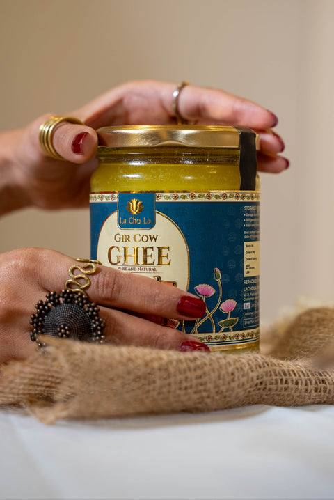 Person holding a jar of ghee with a decorative background